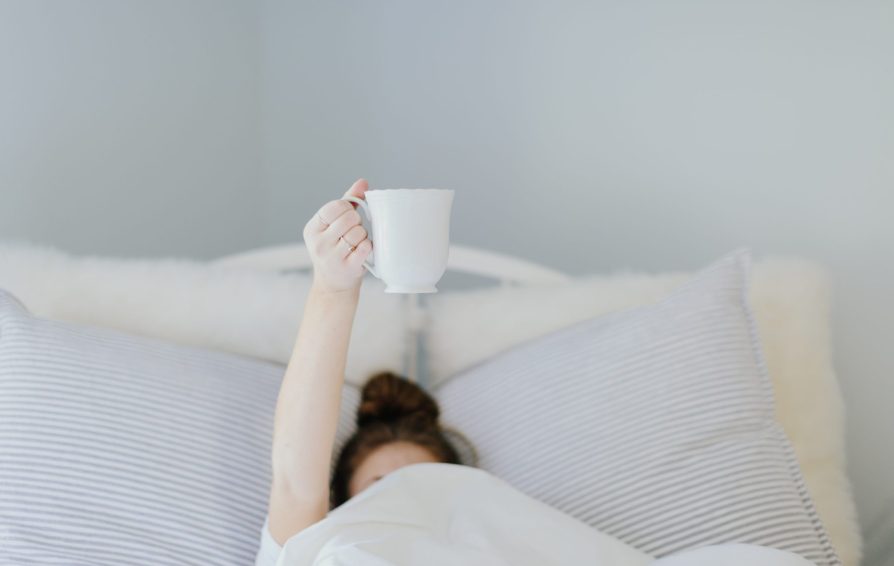person having a cup of coffee to start their morning routine