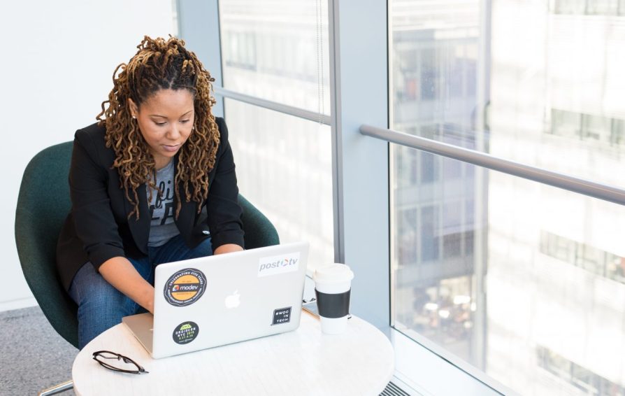 Woman in an office building working at her laptop.