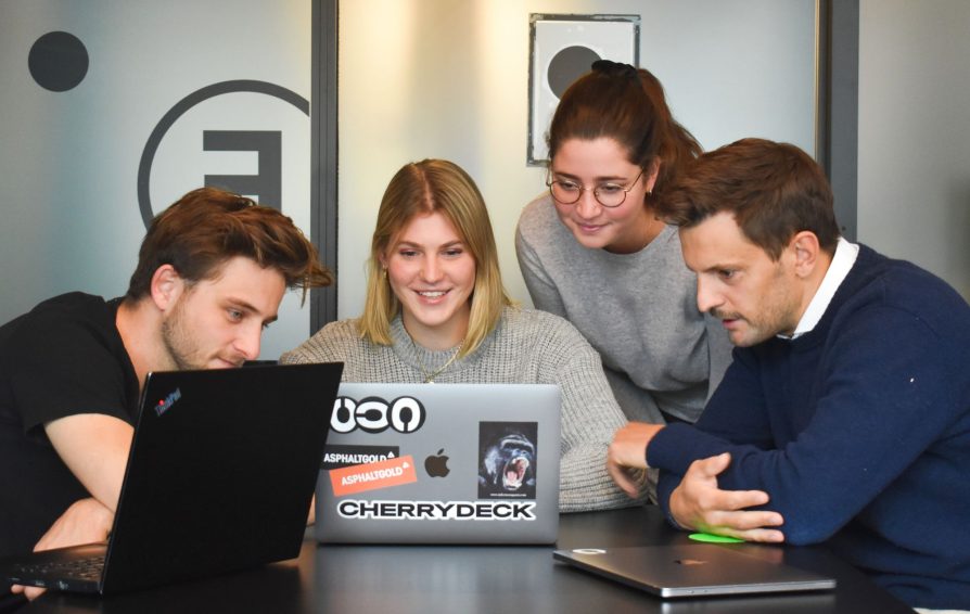 a client onboarding team looks at a laptop.