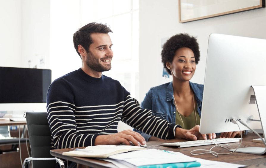 Man and woman at computer learning how to create a workflow