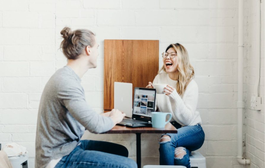Man and woman talking and laughing over a table