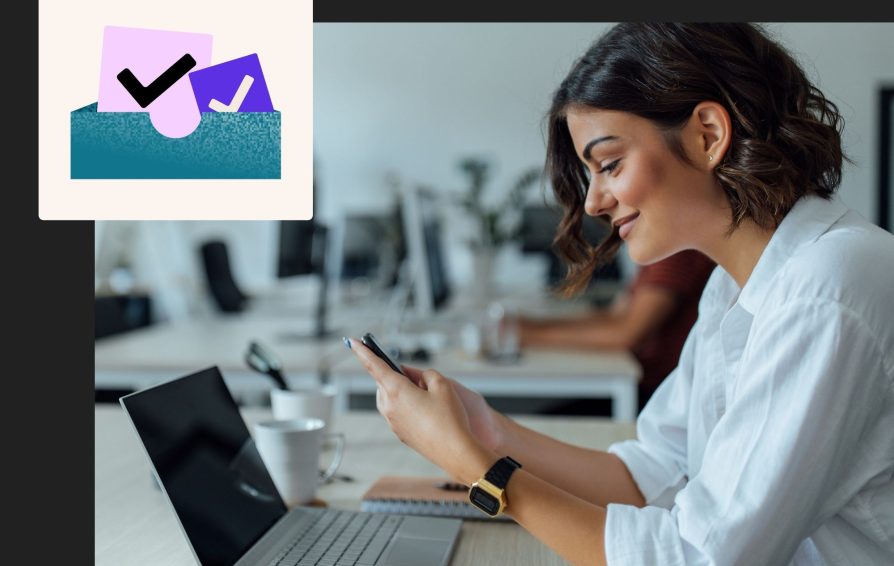 Woman uses phone and computer to check her emails after learning email deliverability best practices.