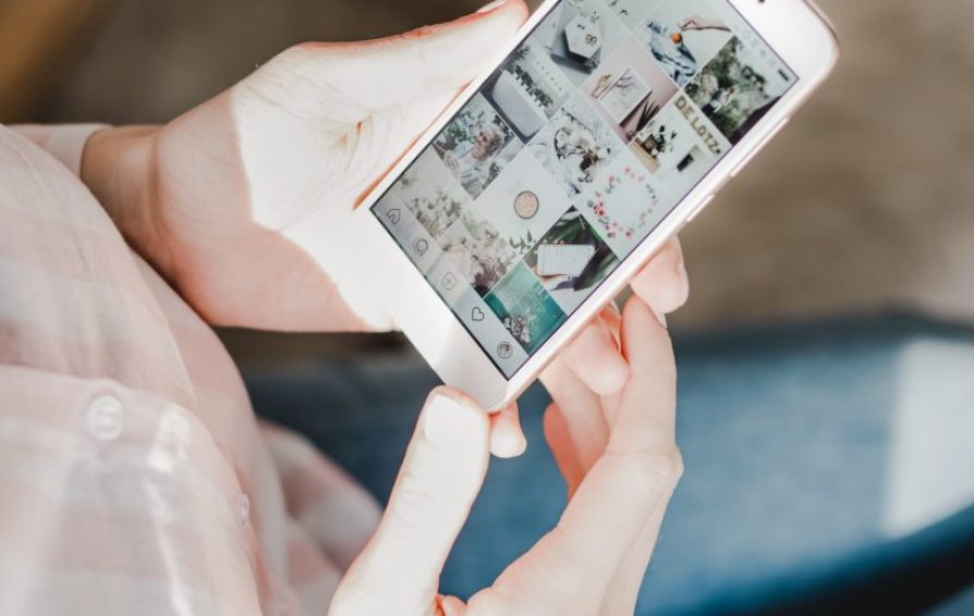 woman holding her phone looking at social media