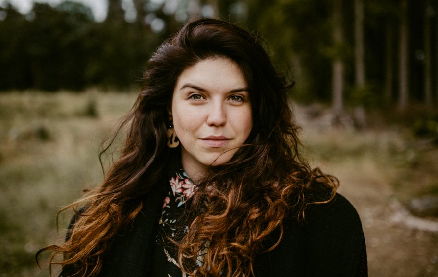 A headshot of a woman standing outside.
