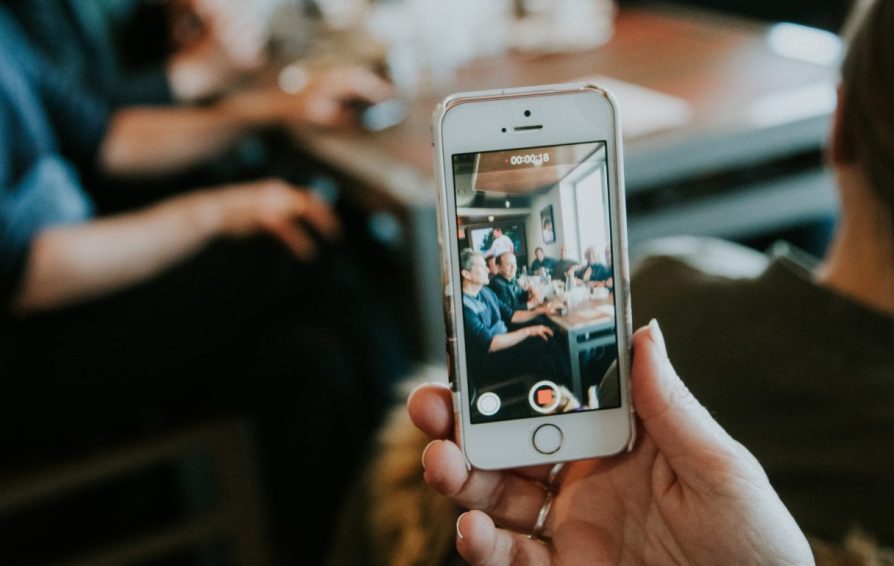 someone holding a phone taking an instagram video of a group of people