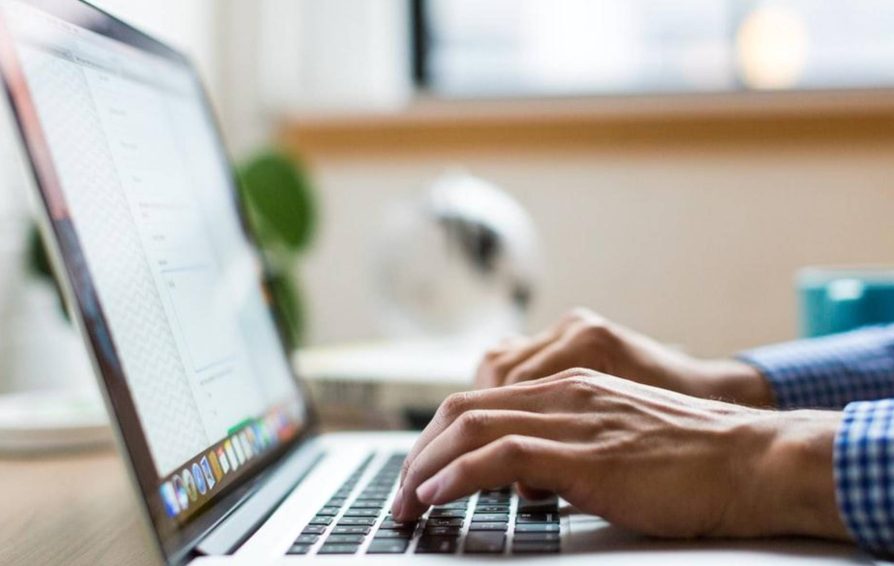 Person writing a business proposal on a laptop