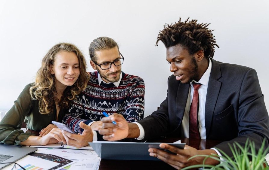 Three people reviewing sales email templates