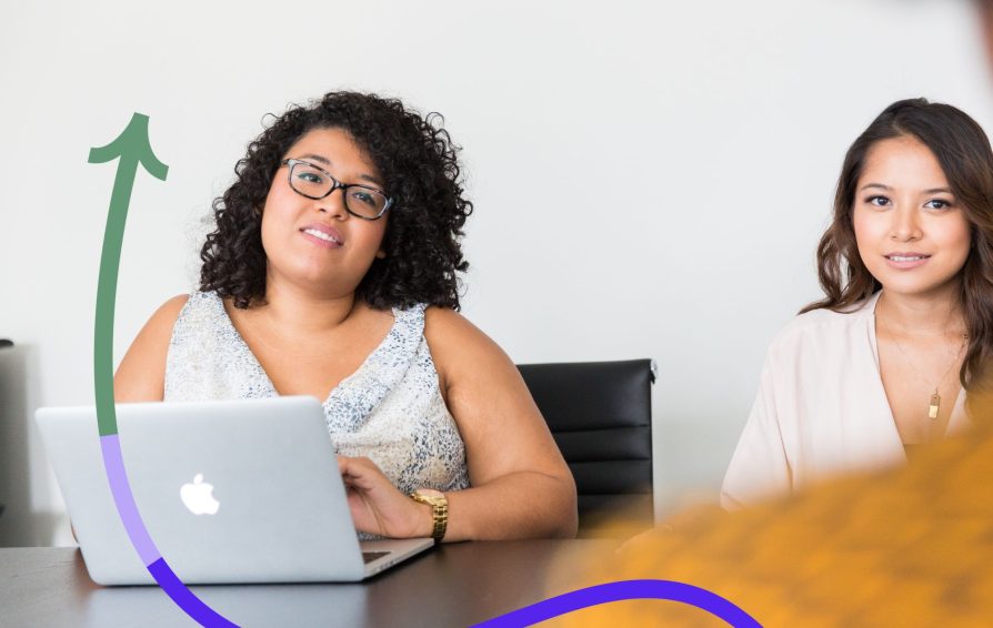 Two women discuss business at a table.