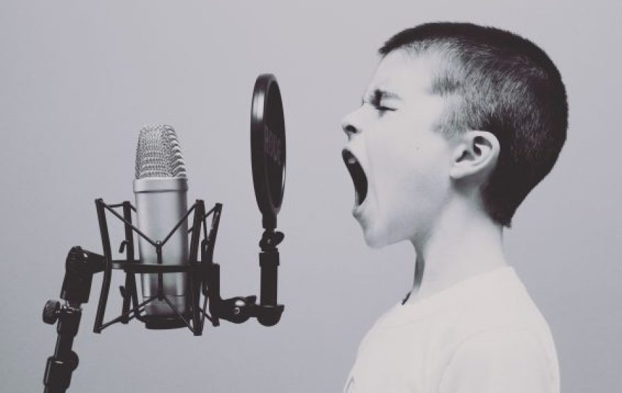 a young boy screaming into a microphone