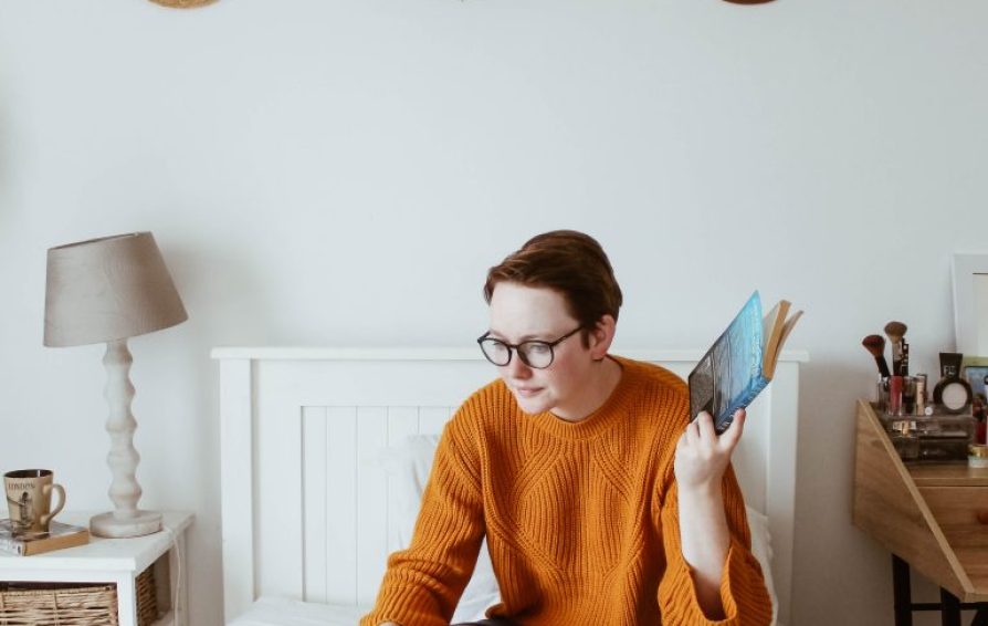woman on a bed with a laptop learning how to create a virtual summit