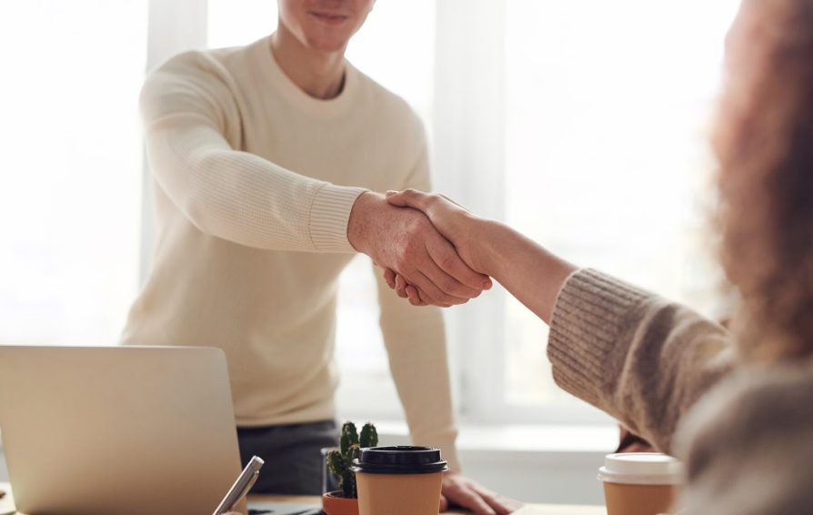 Businessman shaking hands with a client they just won with a sales proposal
