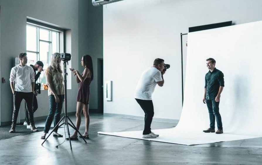 Photographer in a studio taking photos of people
