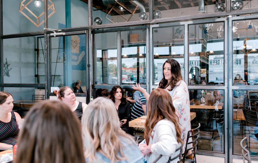 person giving a presentation to a group of people in a coffee shop