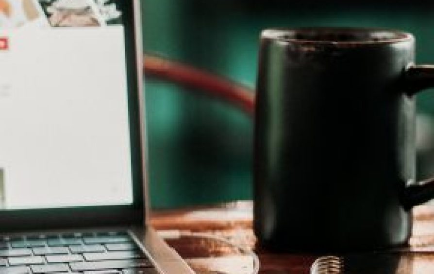 Close up of a laptop and coffee mug
