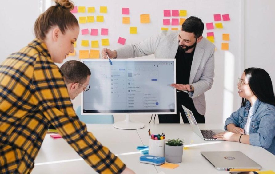 Four employees at a workshop working on a business pitch