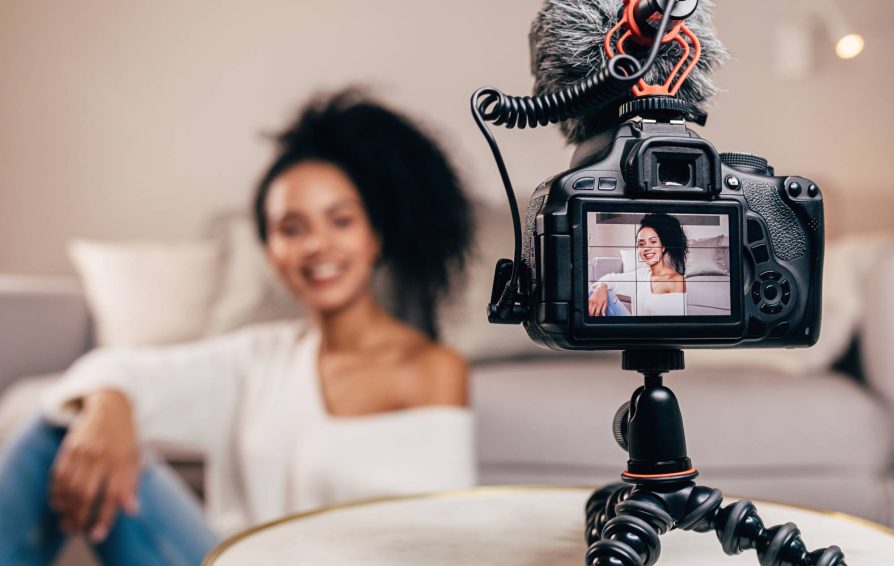 Woman filming a sales video behind a camera