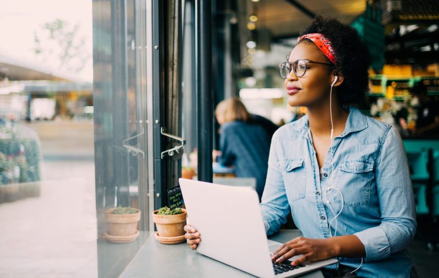 a woman wearing headphones on a laptop learning if a mastermind is right for her business