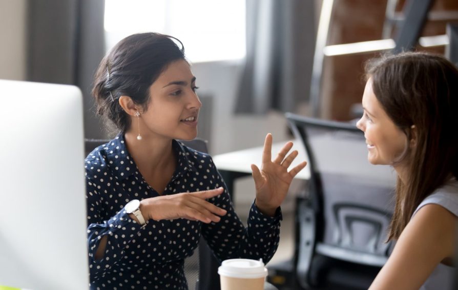 two women talking at a computer about what to look for in a business mentor