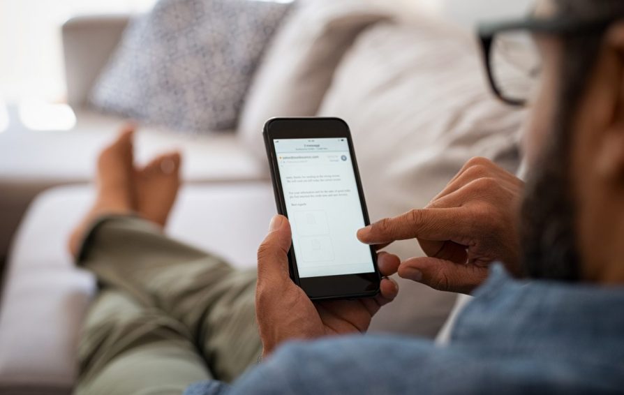 a man on a couch looking at his phone