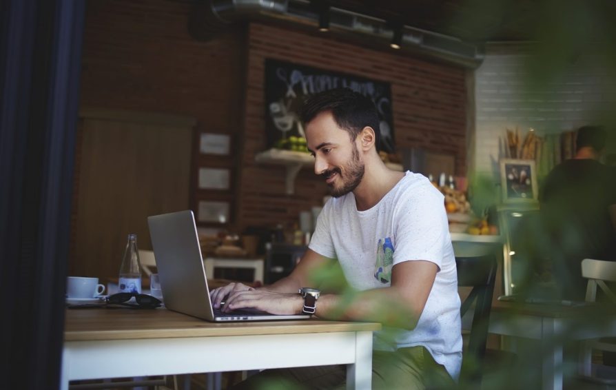 a man sitting at a laptop learning what tasks a freelancer should automate