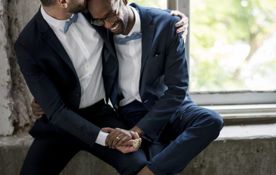 two men smiling and laughing at their wedding