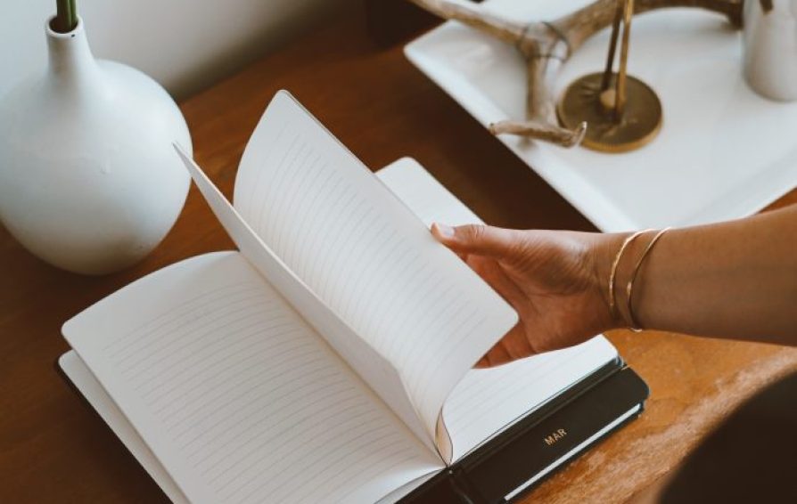 opening a blank notebook to learn how to Create a Vision Statement for Your Business