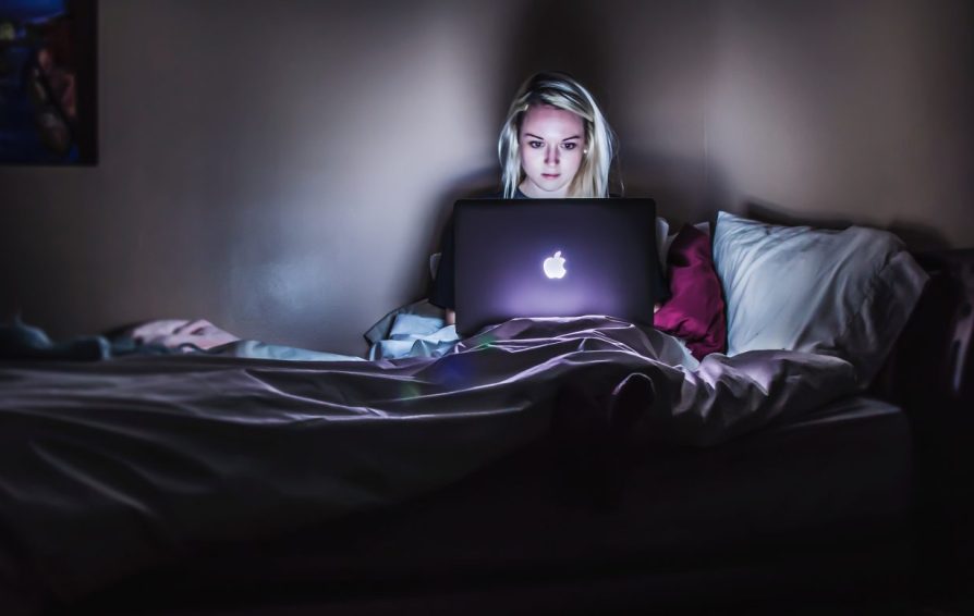 woman working on her laptop at night learning how to manage her clients