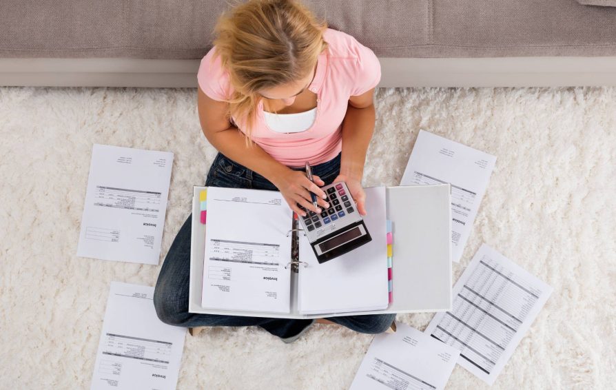 Woman sitting on the floor creating invoices