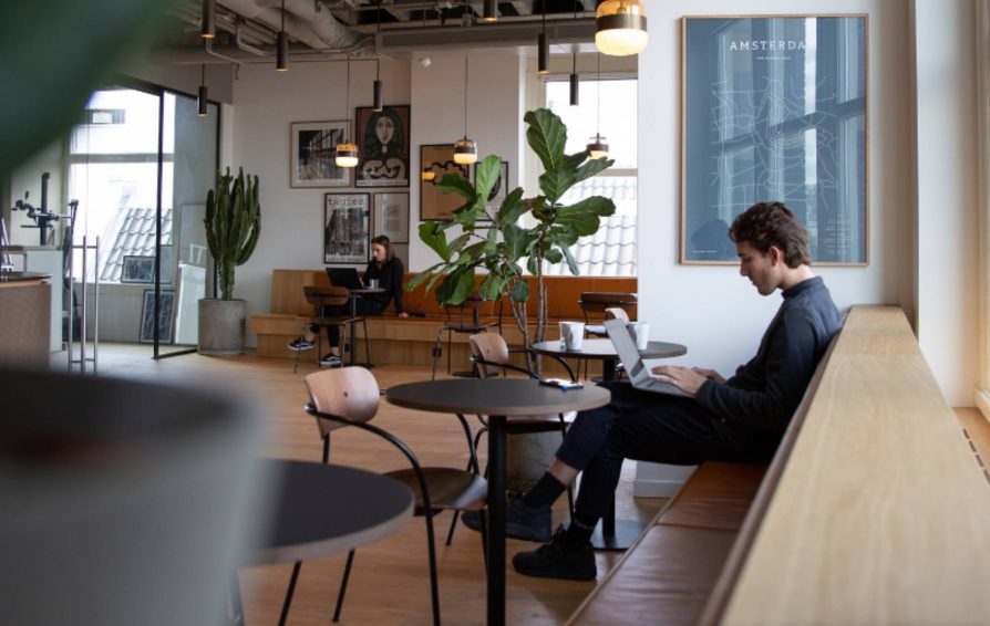 person working at a coffee shop on their laptop