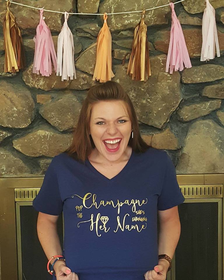 Bride to be smiles while showing off shirt that reads, 