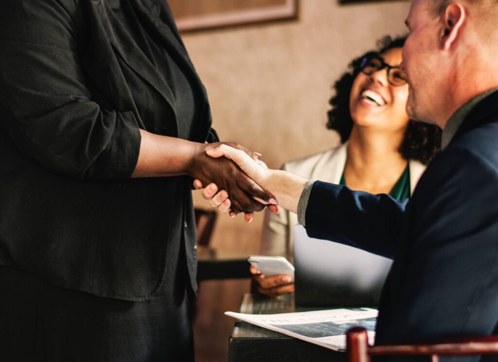 person shaking hands with a client after a branding presentation