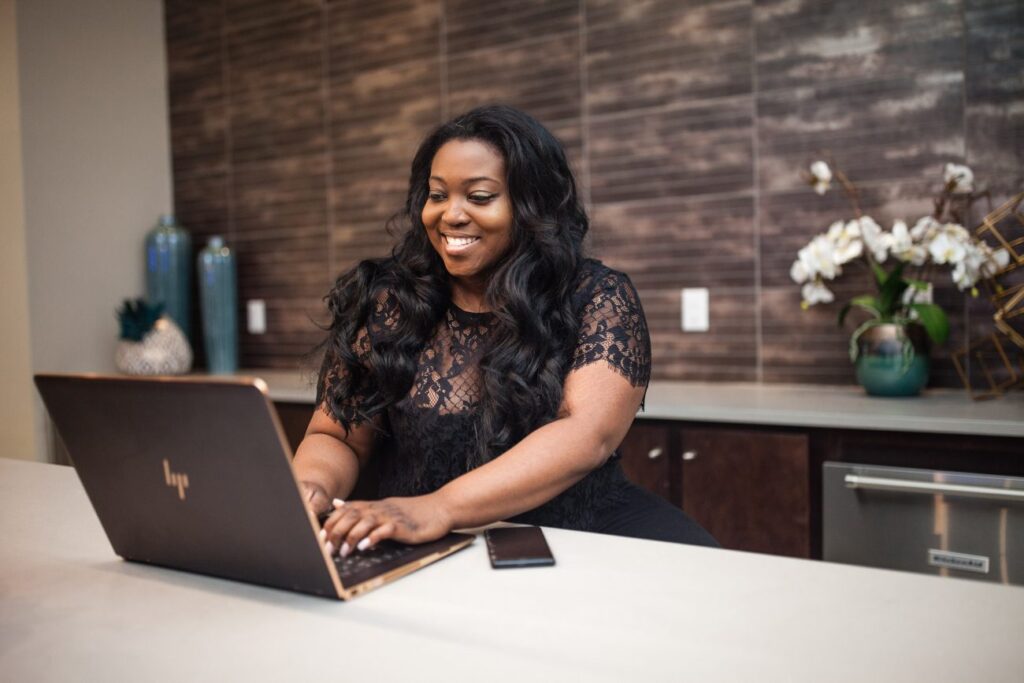 a woman smiling at a laptop learning how to make funnel ads that work